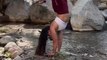 Woman Performs Handstand Variations on the Banks of Small Stream