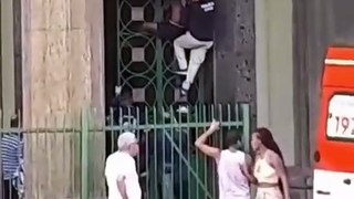 Homem escala portão da sede da Polícia Civil, em Salvador, e é contido por agentes