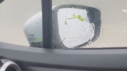 Merciless hailstorm unleashes fury on rear windshield of a car
