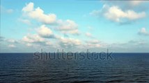 stock-footage-blue-sky-with-white-clouds-moving-panorama-summer-sea-in-light-of-day-aerial-view-of-drone-slide