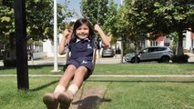 mixkit-happy-little-girl-on-a-swing-in-a-park-8715-medium