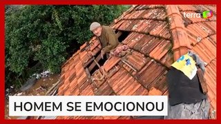 Idoso sorri ao ser resgatado do telhado de casa no Rio Grande do Sul