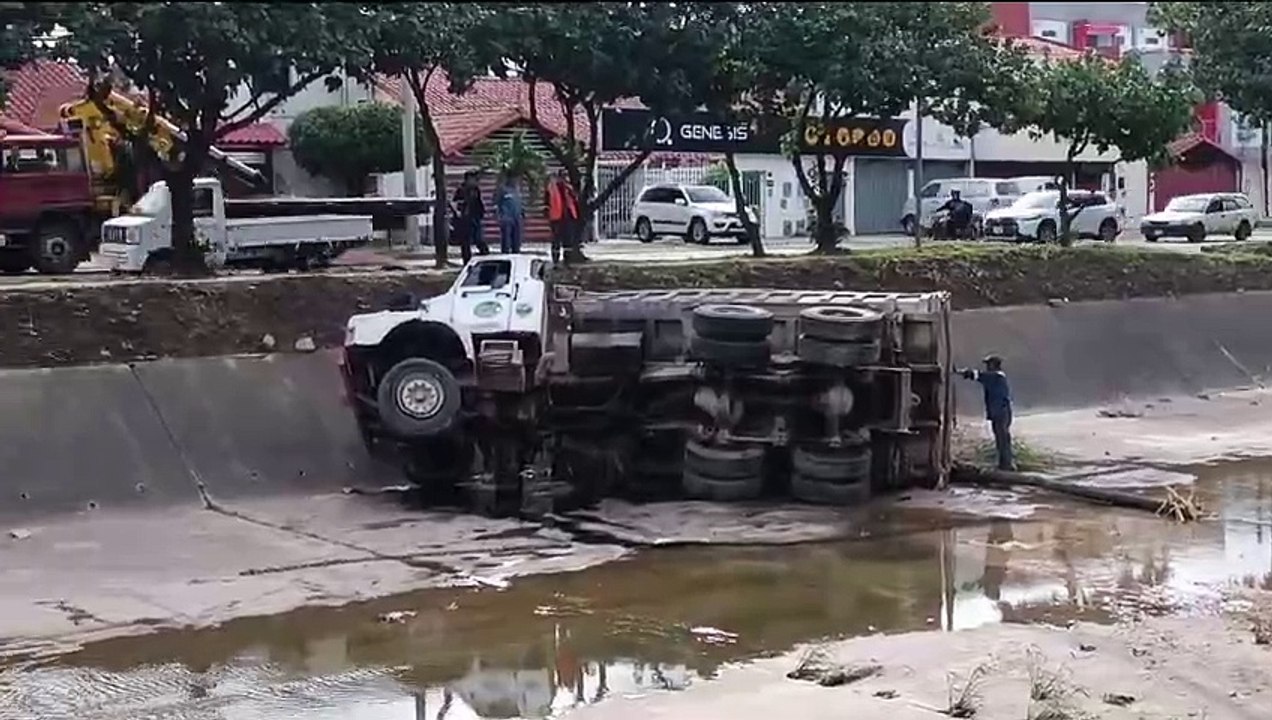 Un camión choca contra árboles y cae al canal d...