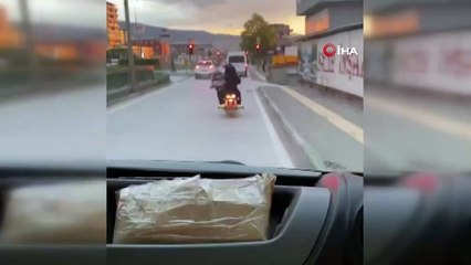 Motosiklet üzerinde bebeği pusetiyle taşıdı