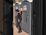 Girl Posing Gets Hit With Portable Toilet's Door When Fellow Kicks it From Inside