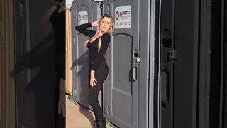 Girl Posing Gets Hit With Portable Toilet's Door When Fellow Kicks it From Inside