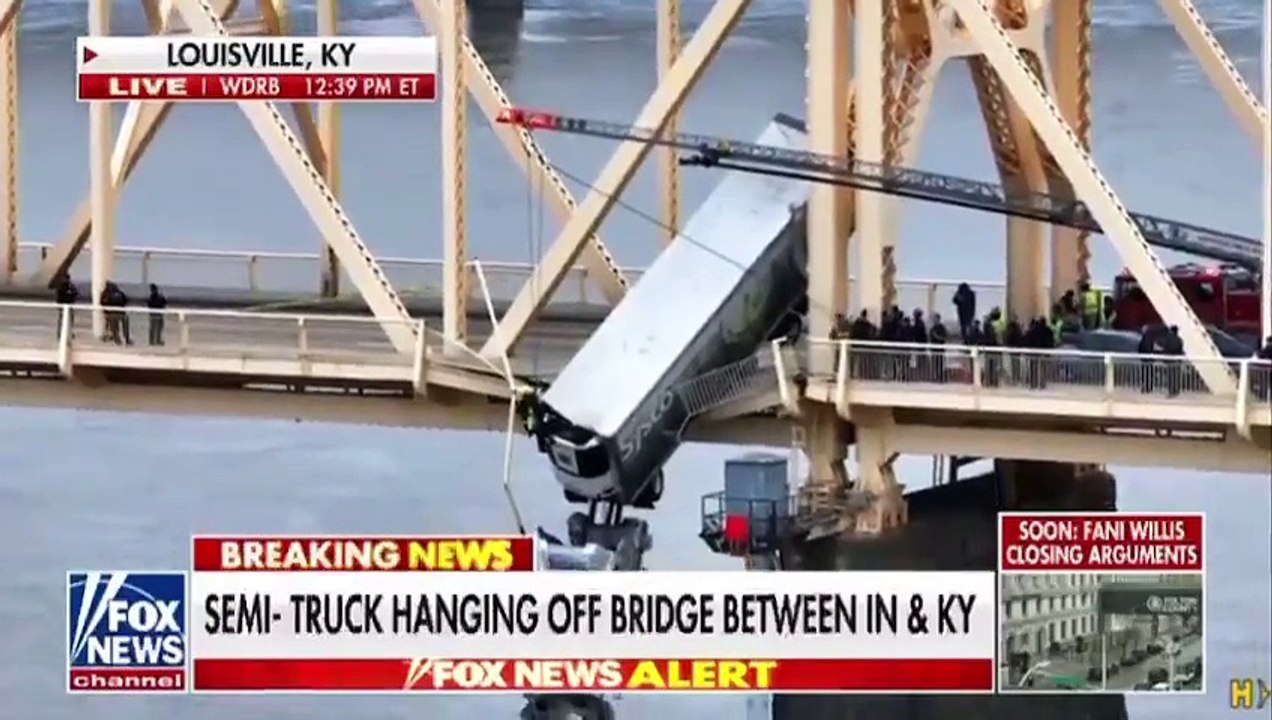 Semi-truck hung dangerously off a bridge connec...