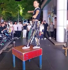 A pretty girl juggling at public place