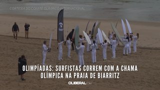 Olimpíadas: surfistas correm com a chama olímpica na praia de Biarritz