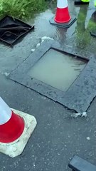 A lifted manhole cover has caused a home's garage and driveway to flood
