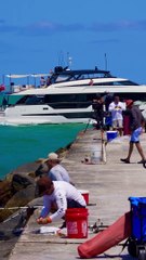 c10M Ferretti Yacht passing the Haulover Inlet jetty and beach in Bal Harbour, Florida