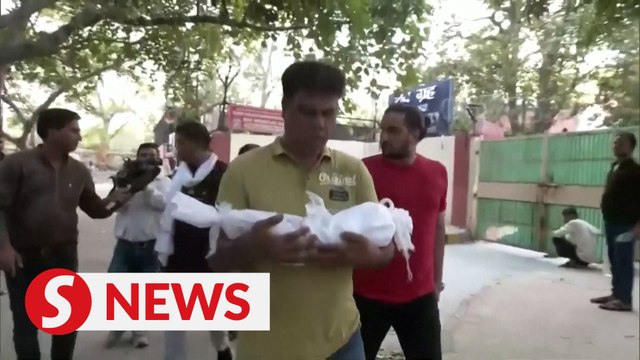 Parents pick up newborns who died in New Delhi fire, as hospital owner arrested