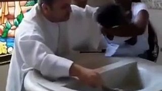 Padre causa polêmica ao dar puxão em criança durante batizado; família prestou queixa