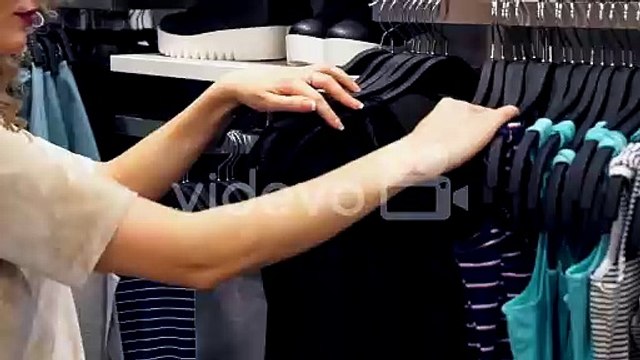 Shopping women choosing clothes in mall or clothing store