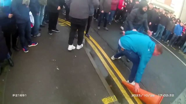 Drunk football supporter wields traffic cone at wall of police