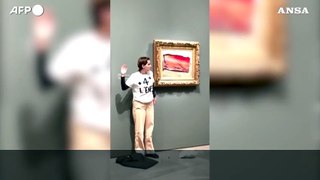 Parigi, una attivista attacca un cartello su un quadro di Monet