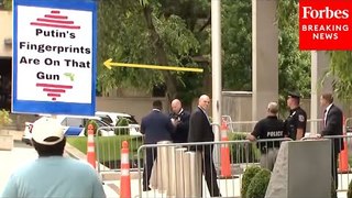 A Man Carries A Sign Reading 'Putin's Fingerprints Are On That Gun' Outside Hunter Biden Courthouse