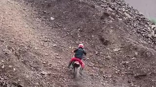 Rider Climbs Slippery Hill With Motorcycle