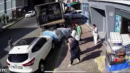 Devrilen yüzlerce kilo su yüklü paletin altında kaldılar. O anlar anbean kameraya yansıdı