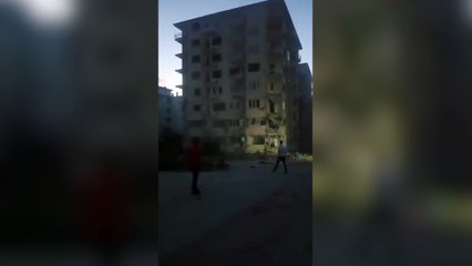 Depremlerde ağır hasar gören binayı taş atarak yıktı