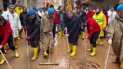 Destici gıcır gıcır çizmeleri giyip sel bölgesine gitti. Yanındaki çıplak ayaklı çocuğun başını okşadı