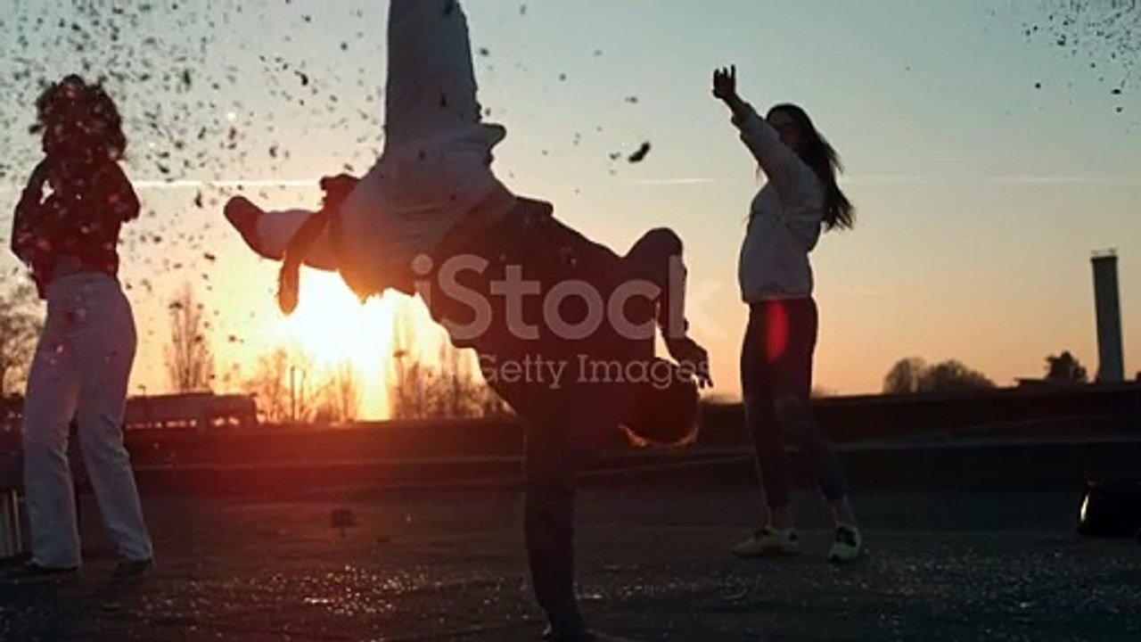Young Man Showing Breakdance Moves While Dancing With Friends