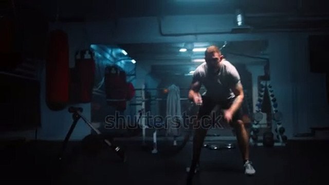stock-footage-male-athlete-exercises-with-battle-ropes-in-dark-boxing-gym-with-led-lighting-professional-boxer