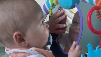 Little boy's infectious laughter as he gazes at his toy mirror