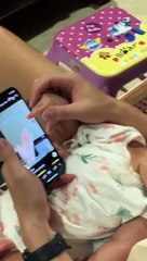 Cute baby - Ayah merawat bayinya sambil menggesekkan ponselnya. Jari-jari baru ini sangat mudah digunakan