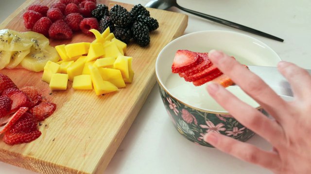 Preparing a bowl with yogurt and fruit