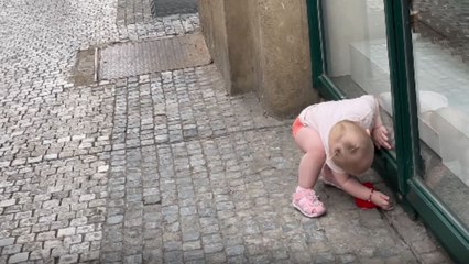 Adorable & independent baby girl will NOT wait for shopkeeper to open the door