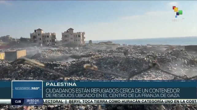 Ciudadanos palestinos están refugiados en campamentos cerca de contenedor de residuos.