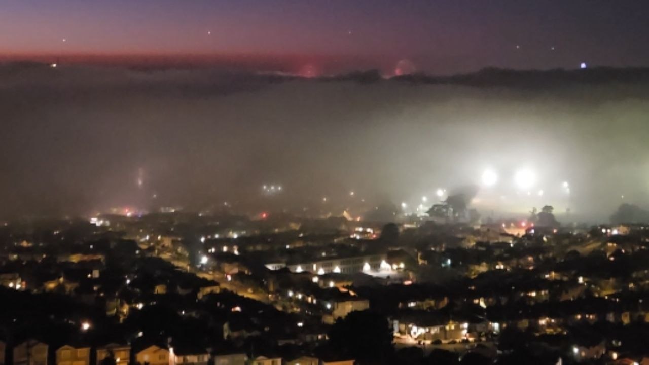 Illegal fireworks display above & under fog in San Francisco on 4th of July