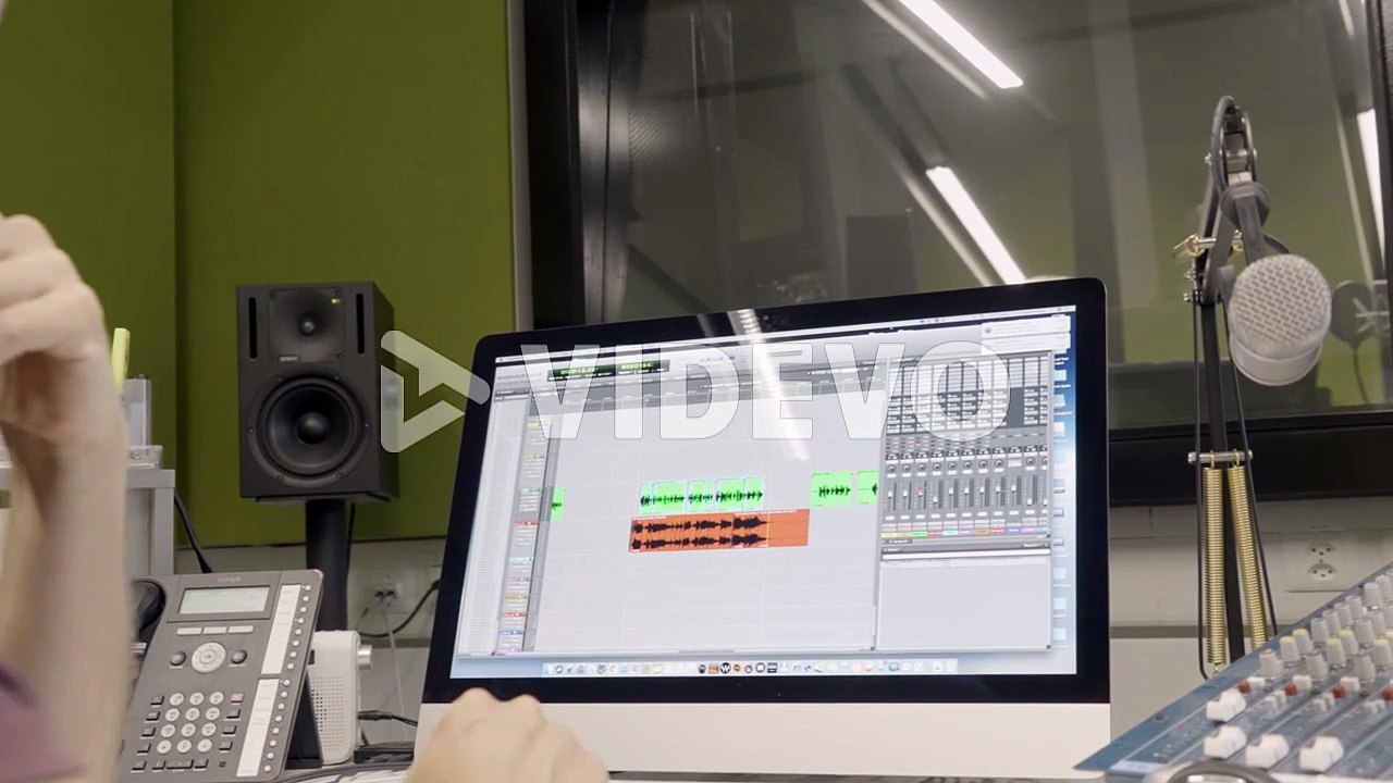 Male audio engineer mixing audio in professional recording studio using audio production software