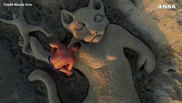 Gattino lanciato nel vuoto, la scultura di sabbia che inverte le parti