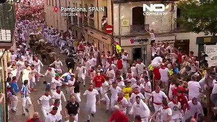 Centenas de pessoas correm à frente de touros bravos pelo bairro antigo de Pamplona