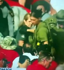 Agentes del orden sacan a alguien de entre la multitud después del tiroteo