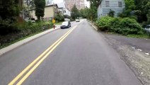 A man riding a bicycle in New York City fell after his leg cramped while climbing a steep hill.