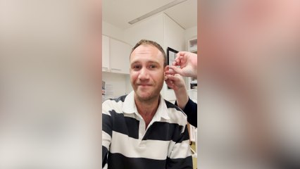 Man's emotional reaction after trying on hearing aid for the first time