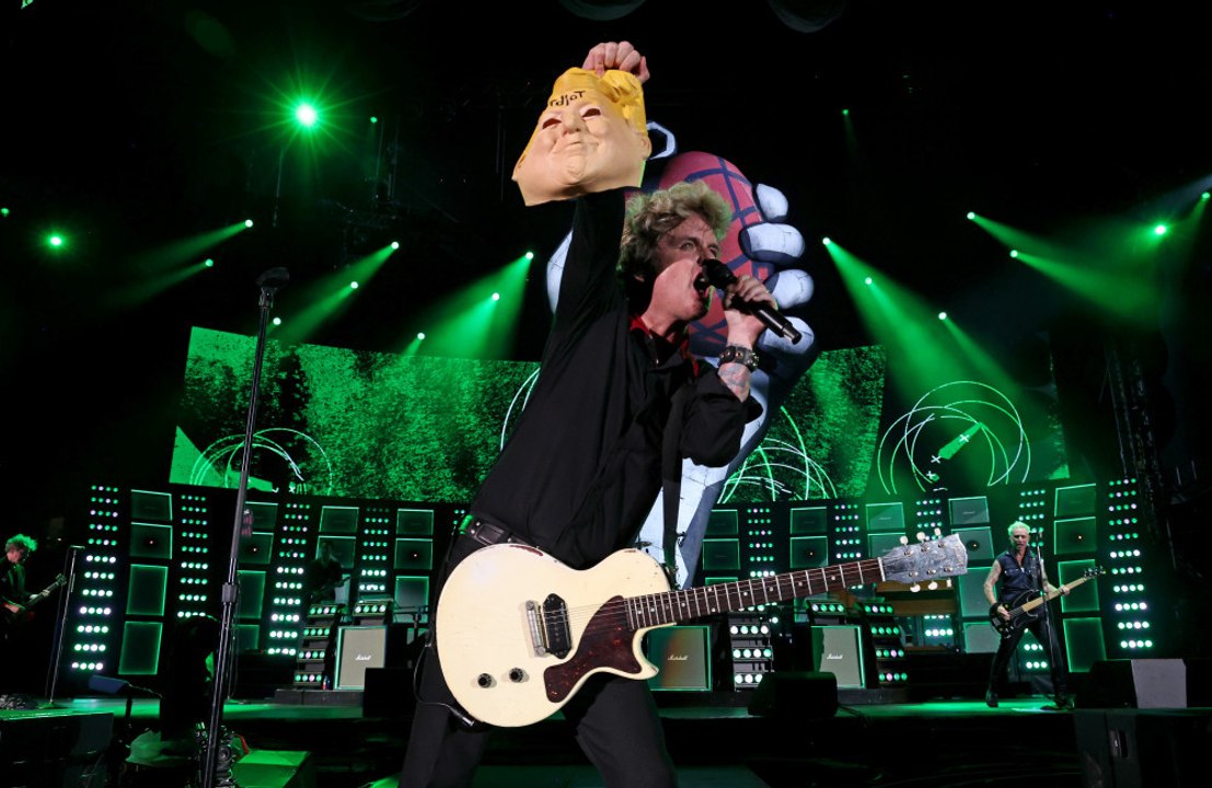 グリーン・デイ、「idiot」と書かれたドナルド・トランプ氏のマスクを掲げる