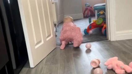 Baby girl remains unbothered by ball-pit balls in her babygrow