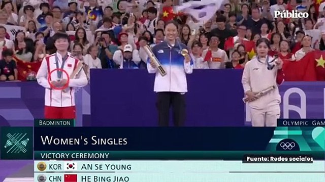 La deportista china He Bingjiao rinde homenaje a Carolina Marín en el podio tras la lesión de la española