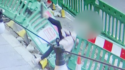 Moment, in dem eine Frau eine Bar verlässt - und geradewegs in einen Gully fällt