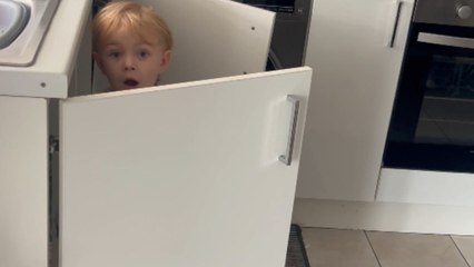 Mom catches the little boy playing with sponges in the kitchen