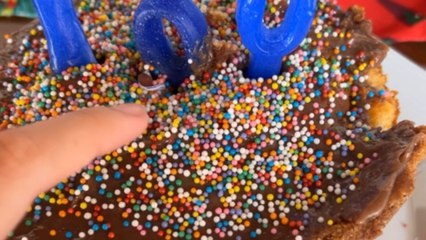 Girl hands clueless dad a birthday cake with a firecracker hidden as a candle