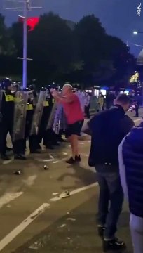 Rioter pushing against police shields is knocked to the ground