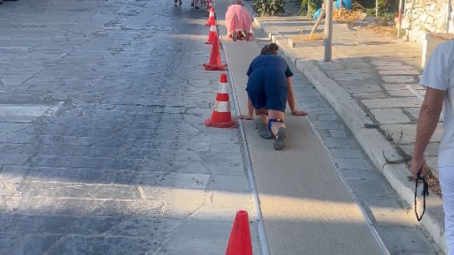 Tinos, Greece: Christians crawling up a carpeted hill in 40 degrees heat to reach church