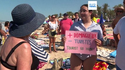 Decenas de activistas se dan un baño contra el turismo de masas en una playa de Mallorca