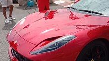 une fille qui chante devant un Ferrari