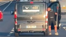 Bizarre moment man hangs out of van - travelling down motorway